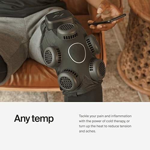 Person using a knee therapy device with both cold and heat settings.