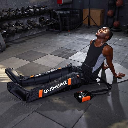 Person using leg compression recovery sleeves in a gym setting.
