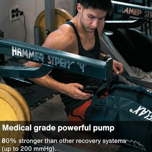 Man using recovery device on legs in gym.