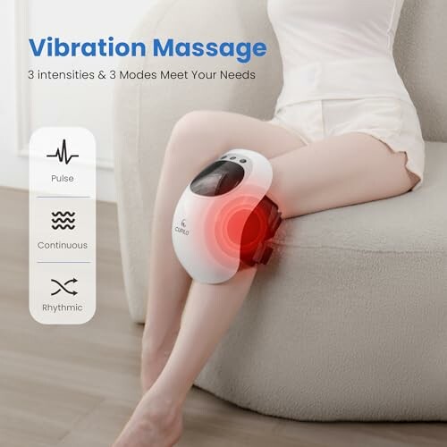 Person using a vibration massage device on their leg with intensity settings displayed.