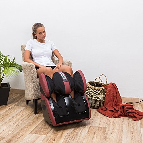 Woman sitting in chair using a foot massager.
